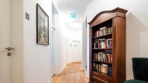 Un couloir doté d’un plancher en bois, d’une bibliothèque et d’une porte sur laquelle figure un numéro.