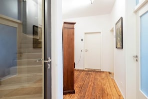 A hallway with a wooden floor, a door, and a wooden cabinet. - Artist room 2.2 - the spacious one (Gera)