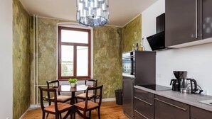A kitchen with dark cabinets, a built-in oven, and a coffee maker. - Artist room 2.2 - the spacious one (Gera)