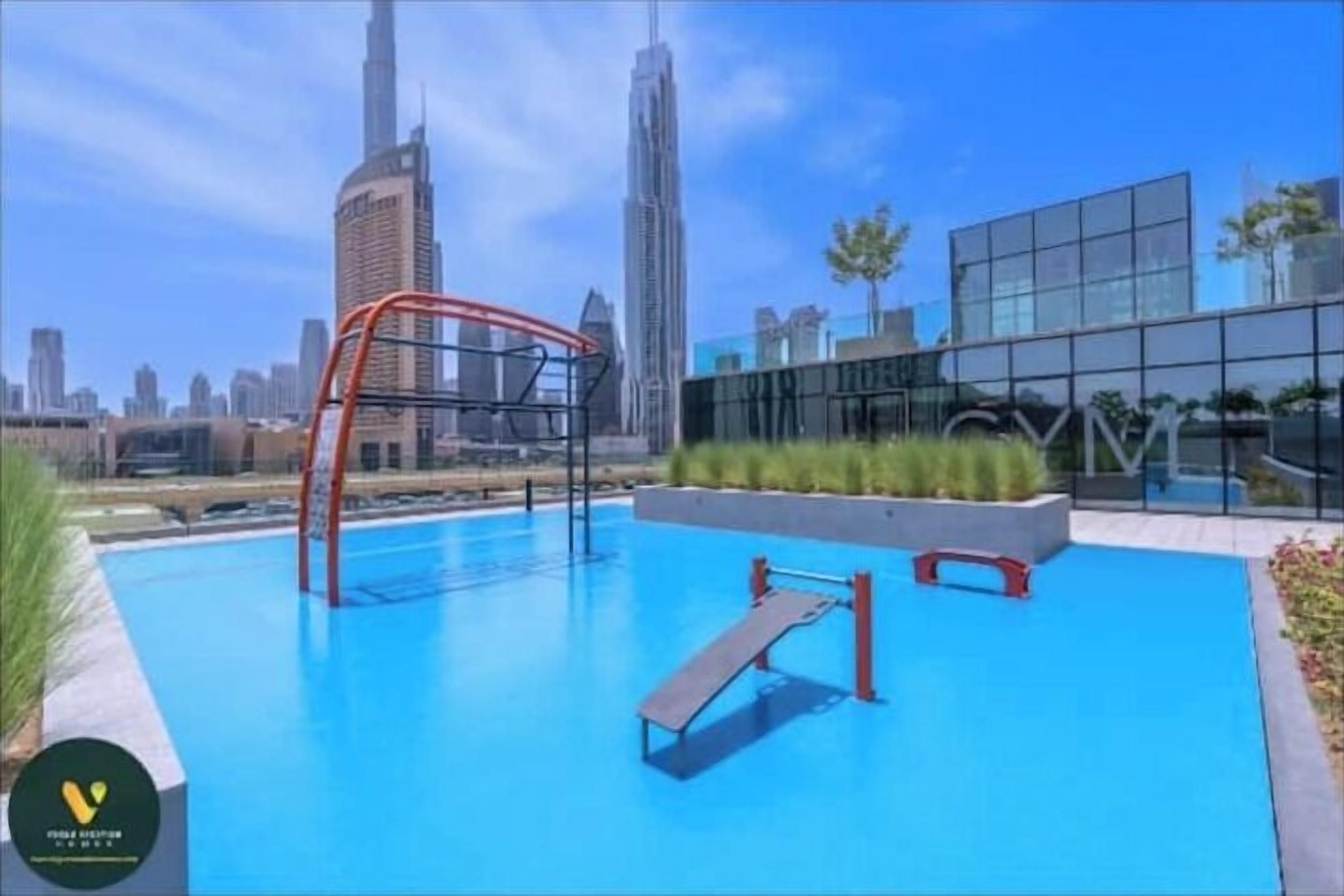 A rooftop pool with a diving board and a cityscape view.