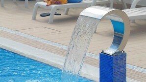 Een zwembad met een moderne waterattractie.