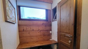 A small room with a slanted wooden desk, a radiator, and a door. - Tignes - 6 pers, 45 m² with WiFi and mountain view (Tignes)