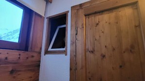 A wooden door with a small window, a wooden wall, and a view of a mountain. - Tignes - 6 pers, 45 m² with WiFi and mountain view (Tignes)
