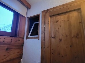A wooden door with a small window, a wooden wall, and a view of a mountain. - Tignes - 6 pers, 45 m² with WiFi and mountain view (Tignes)