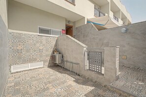 A courtyard with patterned tiles, a metal gate, and a building with a door and windows. - Vacation Apartment 'Oasis Fañabe Townhouse' with Mountain View, Wi-Fi and Air Conditioning (Costa Adeje)