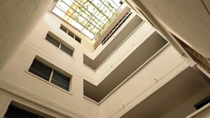 A multi-level interior with a central atrium, multiple staircases, and a series of windows and vents. - ABC-53 (Medellín)
