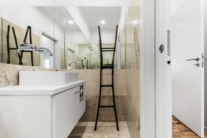 A modern bathroom with a white sink, a mirror, and a black ladder. - Casas da Tapada 1 In front of the wonderful Tapada das Necessidades (Lisboa)