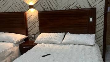 Una cama bien hecha con un detalle dorado, un cabecero de madera y una pared con patrón de espiga.