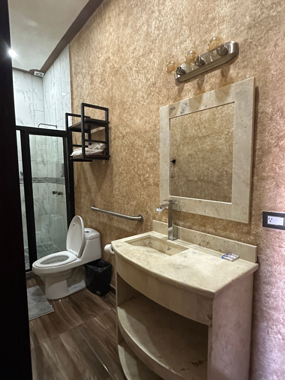 A bathroom with a toilet, sink, and mirror.
