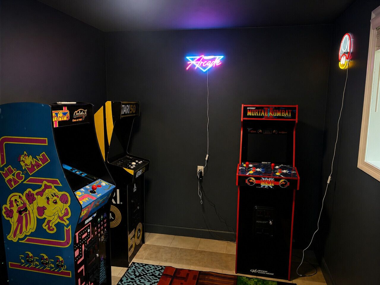 Una habitación con máquinas recreativas, un letrero de neón y una ventana.