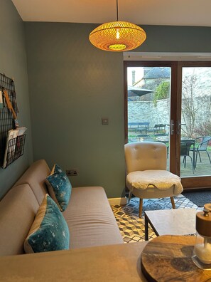 A cozy living room with a sofa, a chair, and a table. There is a large window with a view of the outside. - Modern home, sleeps 8, garden
3km from Cambridge, free carpark (Cambridge)