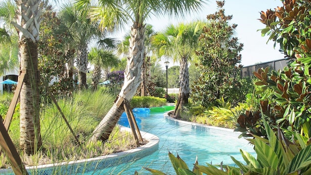 Uma área de piscina com palmeiras e plantas tropicais.
