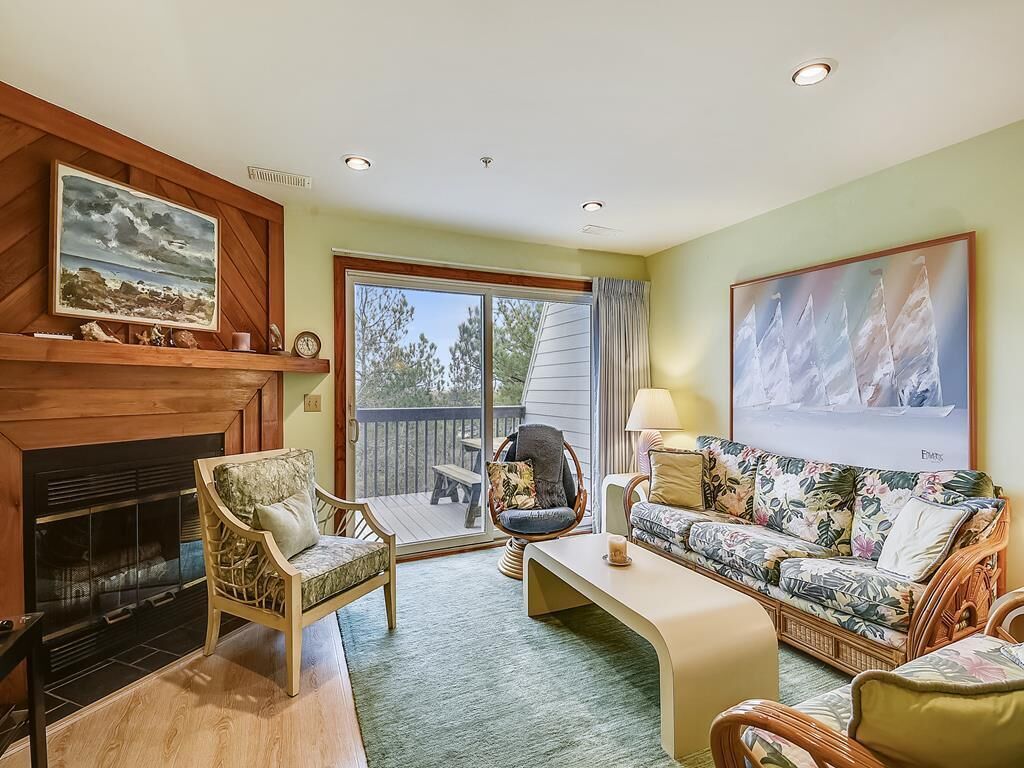 A living room with a fireplace, a sofa, a chair, and a table.