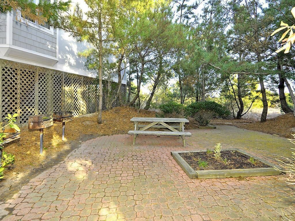 Un patio empedrado con una mesa de picnic y una jardinera.