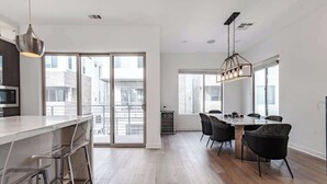 Une cuisine moderne dotée d’un bar, d’une table à manger et de chaises.