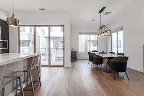 Eine moderne Küche mit Bar, Esstisch und Stühlen.