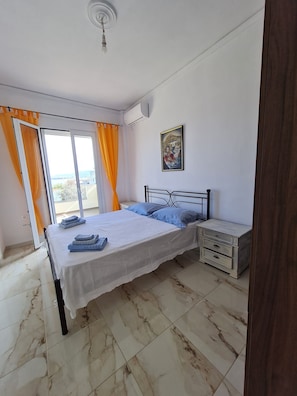 Une chambre à coucher avec un lit, une table de chevet et un tableau accroché au mur.