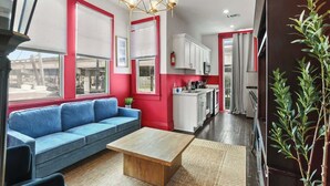 Ein modernes Interieur mit einem blauen Sofa, einem Holztisch und einer Küchenzeile.