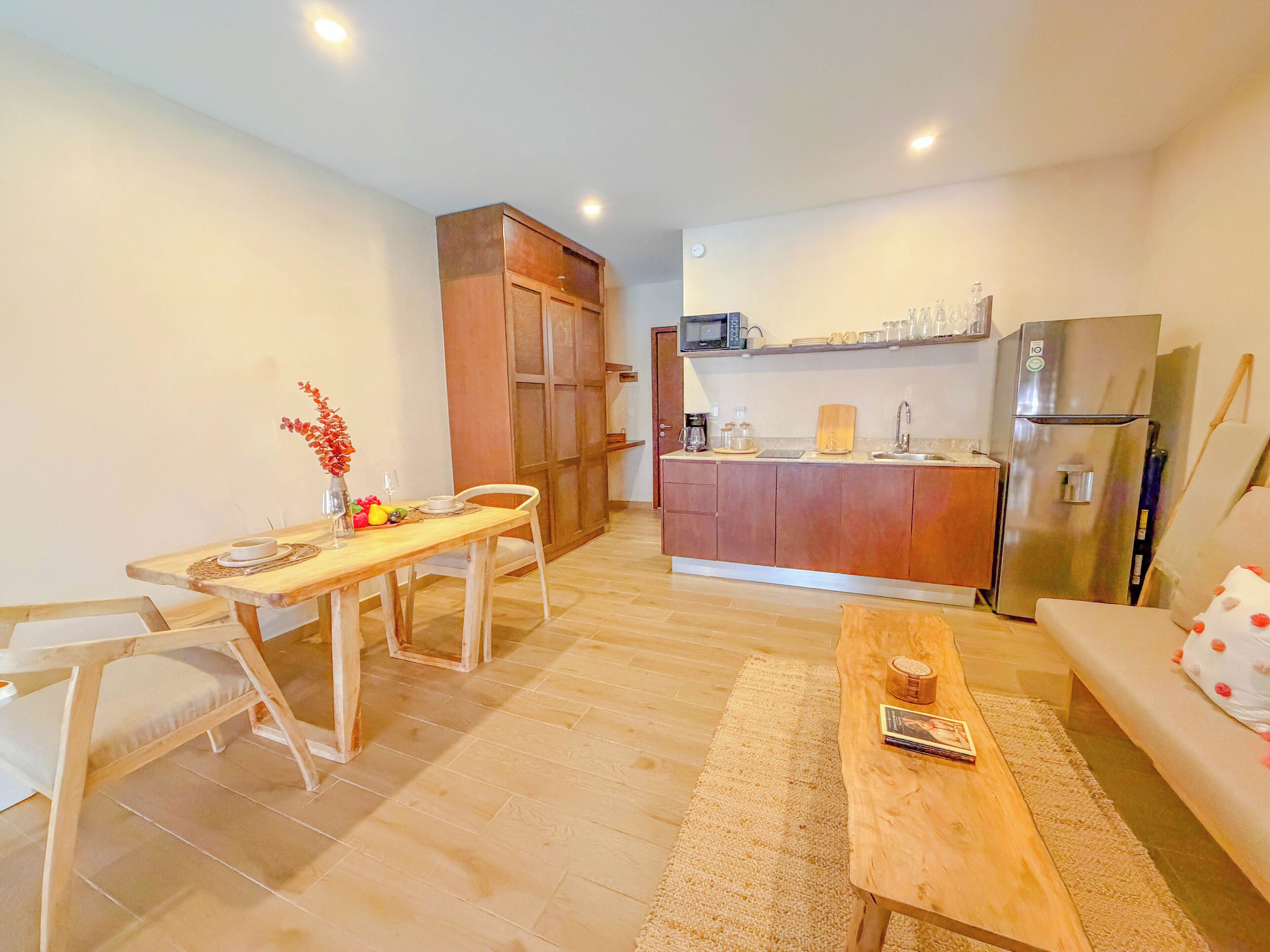 Un espace de vie compact comprenant un coin repas, une kitchenette et un canapé.