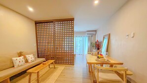 Een moderne woonkamer met een bank, salontafel, eettafel en stoelen.