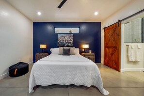 A bedroom with a large bed, two bedside tables with lamps, a wooden door, and a painting on the wall. - House & Casita / Sam Hughes / Total of 4 BR & 3 BA (Tucson)