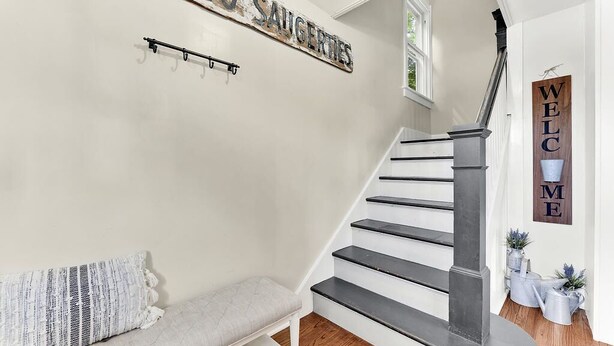 A staircase with a metal handrail and a bench with a striped cushion.