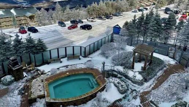 A snow-covered outdoor area with a swimming pool, a parking lot, and a view of mountains. - Ski In Ski Out Top Floor 2 BR Seneca Corner Unit. Newly Renovated-Garage Parking (Snowshoe)