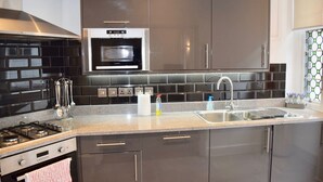 Una cocina moderna con horno empotrado, electrodomésticos de acero inoxidable y encimera de granito.