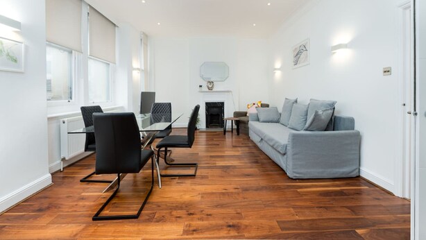A spacious living room with a dining area, a fireplace, and a sofa. - Central London Flat FS1 (London)