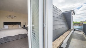 A bedroom with a bed, bedside tables, and a window with blinds. - Stylish 3 Bedroom Flat CRC (London)