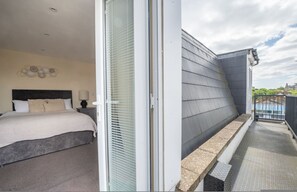 A bedroom with a bed, bedside tables, and a window with blinds. - Stylish 3 Bedroom Flat CRC (London)