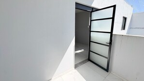 Un edificio moderno con fachada blanca y un amplio ventanal de vidrio que da a un espacio interior.
