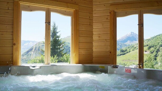 A wooden cabin with a hot tub and large windows offering mountain views. - Chalet with terrace - 7 guests (Saint-Sorlin-d'Arves)