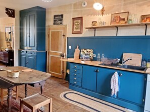 A kitchen with blue cabinets, a wooden table, and a vintage toaster. - Charming house in a peaceful area - 6 guests (Ménil-sur-Saulx)