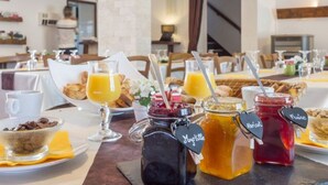 Un buffet de petit-déjeuner proposant une variété d’aliments et de boissons, notamment des pots de miel et de confiture, ainsi qu’un bol de chocolat.