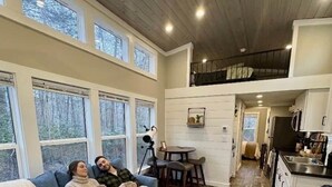 A cozy living room with a couch, coffee table, and a dining area with a table and chairs.