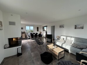 Een moderne woonkamer met een grijze bank, een bijzettafeltje en een tv op een dressoir.