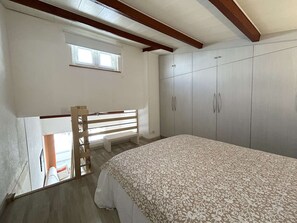 A bedroom with a bed, wardrobe, and a window. - Studio loft near the port - 4 guests (Cap d'Agde)