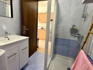 A bathroom with a sink, mirror, and shower area. - Charming duplex near the sea, 4 guests (Borgo)