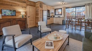 Uma cozinha moderna com armários de madeira, uma área de jantar com uma mesa grande, e vista para arquitetura tradicional lá fora.