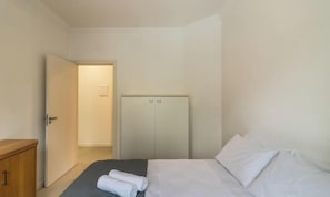 A hotel room with a bed, a wardrobe, and a door leading to another room. - Apt w/ BBQ 350m From the Beach Apv0202 (Itapema)