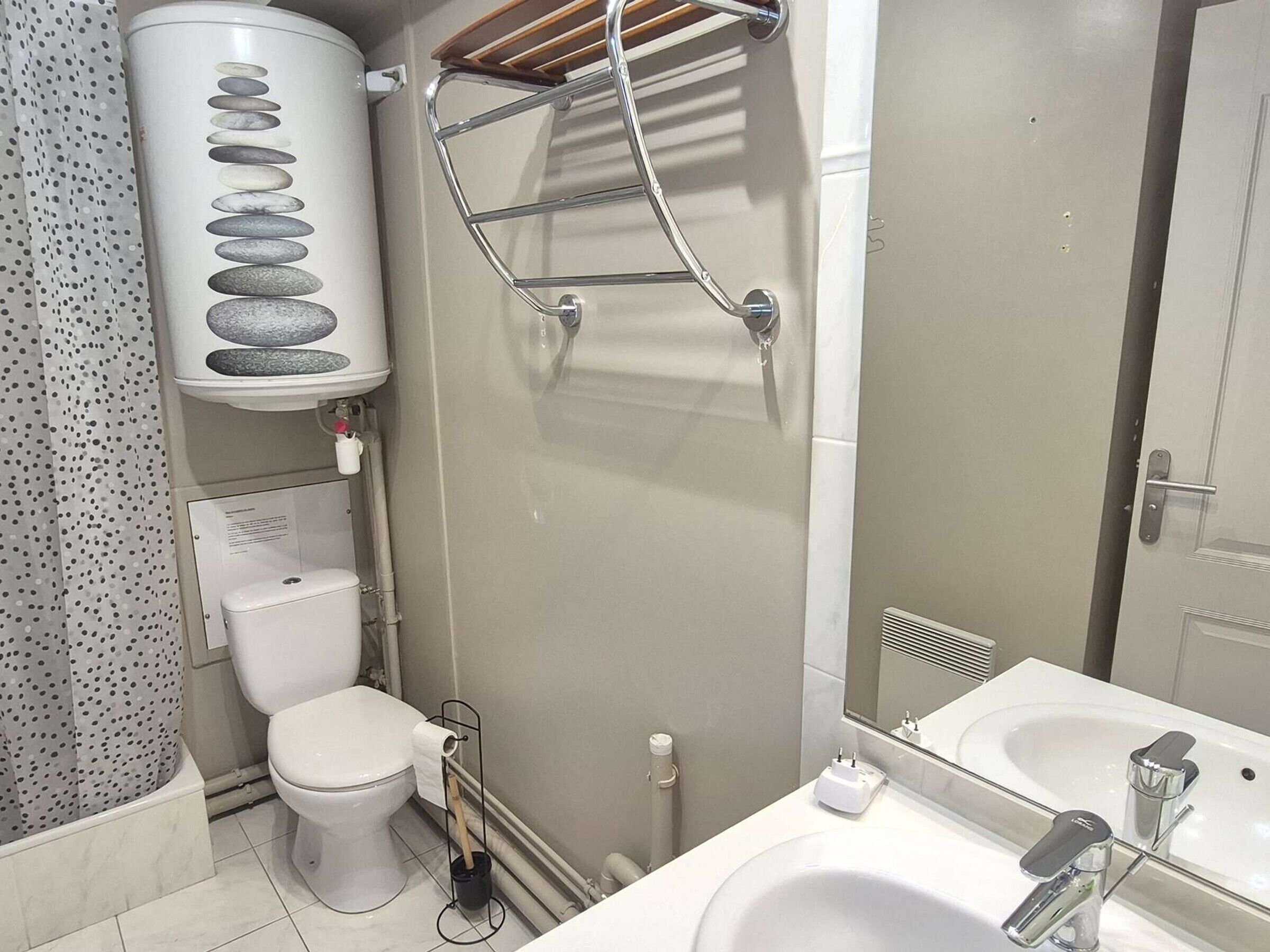 A modern bathroom with a toilet, shower, and sink.