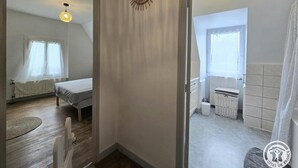 Ein Schlafzimmer mit einem Bett, einem kleinen Tisch und einer Pendelleuchte.
