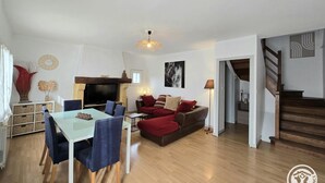 Ein geräumiges Wohnzimmer mit Essbereich, Kamin und einer Treppe, die zu einer weiteren Ebene führt.