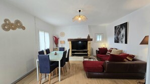 Ein Wohnzimmer mit Essbereich, Kamin und einer Couch.