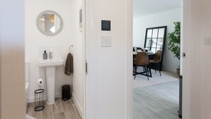 Et moderne badeværelse med vask, spejl og toilet.