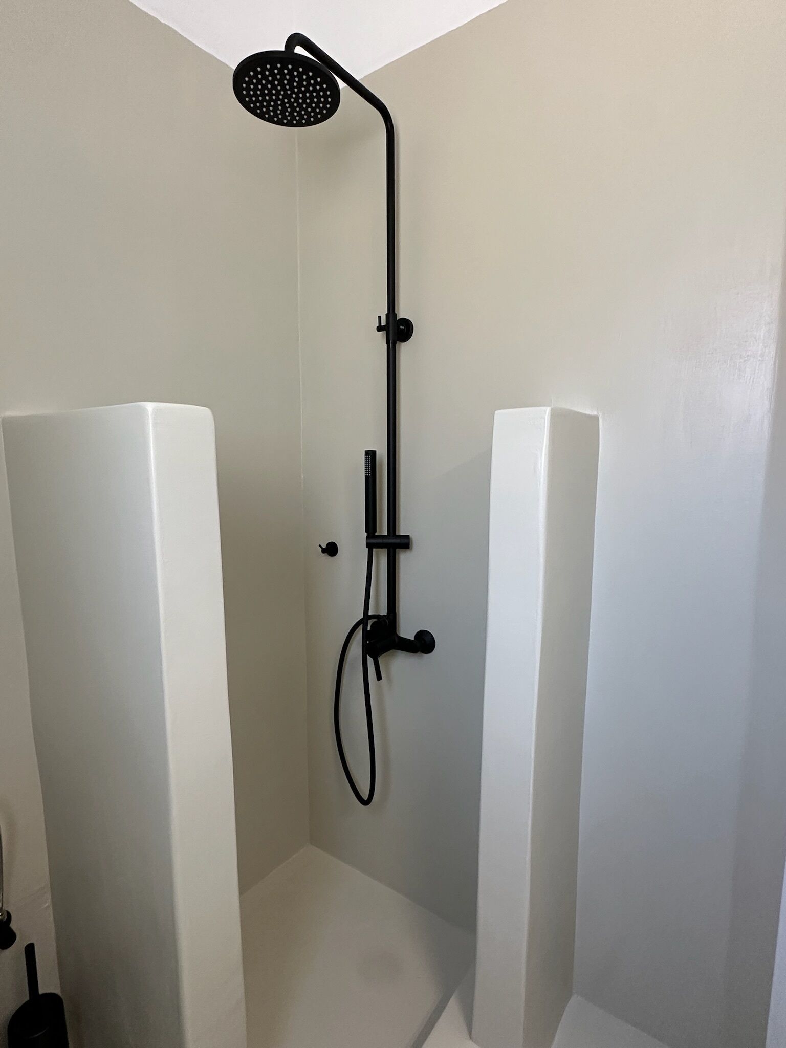 Eine Dusche mit Duschkopf, Handbrause und Reinigungsaufsatz.