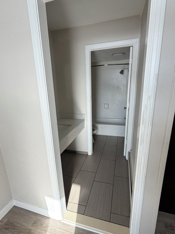 A small bathroom with a shower, toilet, and vanity. - northborough inn (Northborough)