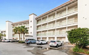 A multi-story hotel with a parking lot in front. - The Inn at Seacrest Beach Unit 207 (Alys Beach)