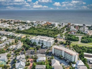 An aerial view of a coastal town with a prominent hotel featuring a central courtyard and multiple parking areas. - The Inn at Seacrest Beach Unit 207 (Alys Beach)